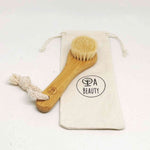 Soft Detox & Glow Face Brush with bamboo handle and goat bristles, displayed alongside a branded cotton storage pouch.